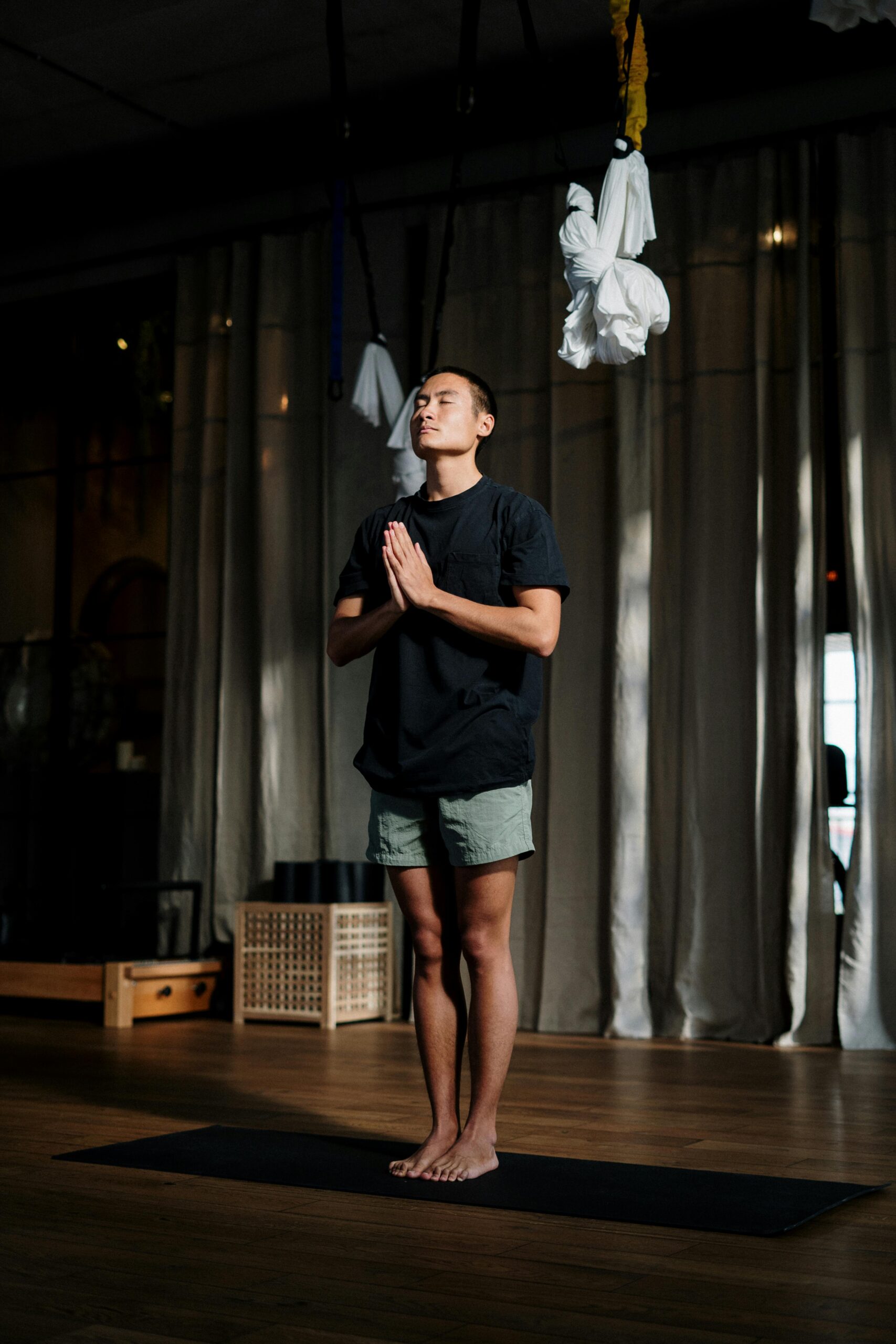 Woman in Blue Crew Neck T-shirt and Black Shorts Standing on Brown Wooden Floor