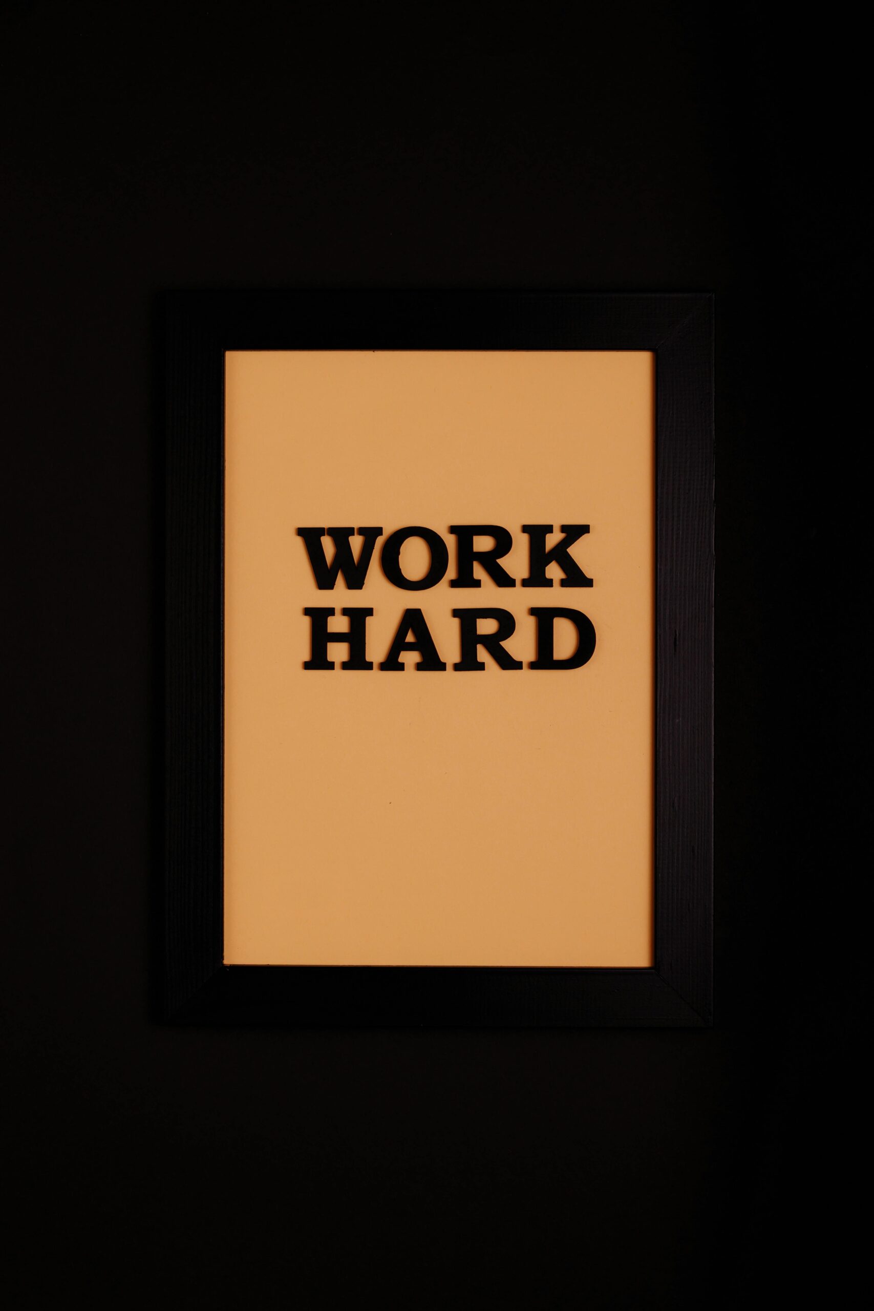 Framed wall art with bold 'Work Hard' text on a warm background for motivation.